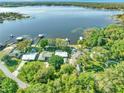 Stunning aerial view of a lakeside property showcasing lush greenery and serene water views at 10900 Se Timucuan Rd, Summerfield, FL 34491