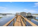 Picturesque view of a private dock on the lake, complete with boat house and charming details at 10900 Se Timucuan Rd, Summerfield, FL 34491
