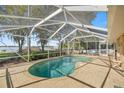 Inviting screened-in pool area with a brick patio, perfect for outdoor relaxation and entertaining at 10900 Se Timucuan Rd, Summerfield, FL 34491