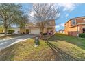 Charming two-story home with a two car garage, beautiful landscaping, and a walkway to the front door at 12312 Ne 48Th Loop, Oxford, FL 34484