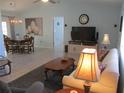 Open-concept living room features neutral walls, tile flooring, ceiling fan and a comfortable seating area at 13779 Sw 115Th Cir, Dunnellon, FL 34432