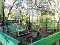 Charming fenced garden with raised beds, protective cages, and lush greenery at 19390 Se 95Th Pl, Ocklawaha, FL 32179
