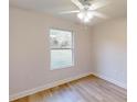 Cozy bedroom features wood-look flooring, a ceiling fan, and natural light from the window at 24264 Sw South Hills Ct, Dunnellon, FL 34431