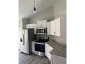 Stylish kitchen features granite countertops, stainless steel appliances, and white cabinetry at 4721 Nw 67Th St, Ocala, FL 34482