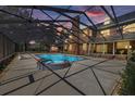 A luxurious screened pool with a connected spa and ample space for relaxation and entertainment at 4940 E Fort King St, Ocala, FL 34470
