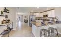 Open-concept kitchen with granite countertops, stainless steel appliances, and eat-in breakfast bar at 8470 Las Palmas Way, Wildwood, FL 34785
