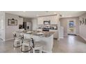 Bright kitchen featuring an island with bar stool seating, stainless steel appliances, and ample counter space at 8474 Las Palmas Way, Wildwood, FL 34785