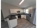 An open kitchen has stainless appliances, grey counters and white cabinets at 1 Fisher Lane Way, Ocklawaha, FL 32179