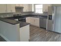 Bright kitchen features stainless steel appliances, gray countertops, and ample white cabinetry at 1 Fisher Lane Way, Ocklawaha, FL 32179