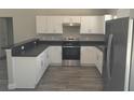 Updated kitchen showcasing stainless steel appliances, gray countertops and stylish wood-look flooring at 1 Fisher Lane Way, Ocklawaha, FL 32179