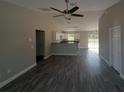Bright, open living room with modern flooring leading to a well-lit kitchen and access to the backyard at 1 Fisher Lane Way, Ocklawaha, FL 32179