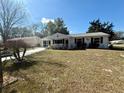 Inviting single-story white home with manicured lawn and well-maintained landscaping at 10824 Sw 90Th Ter, Ocala, FL 34481