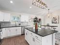 Well-lit kitchen with white cabinets, granite countertops, and stainless steel appliances at 14605 Sw 20Th Pl, Ocala, FL 34481