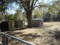 Backyard with three storage sheds and a large tree providing plenty of shade at 18800 Sw 31St St, Dunnellon, FL 34432