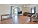 Cozy living room showcasing wood floors, plush seating, and sliding glass door access at 2209 Nw 55Th Avenue Rd, Ocala, FL 34482