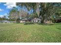 Inviting single-story home featuring a spacious green lawn and mature trees providing ample shade at 2923 Se 14Th St, Ocala, FL 34471