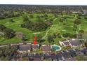 Aerial view of condo buildings, parking, and swimming pool backing to the golf course at 3437 E Fort King St # 220, Ocala, FL 34470