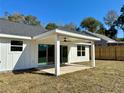 Outdoor back porch features a ceiling fan and glass sliding doors for indoor-outdoor living at 3684 Se 130Th Pl, Belleview, FL 34420