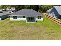 Aerial view of large backyard with fresh sod, privacy fence and covered patio at 3684 Se 130Th Pl, Belleview, FL 34420