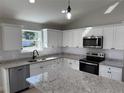 Well lit kitchen with stainless steel appliances, granite countertops and white cabinetry at 3684 Se 130Th Pl, Belleview, FL 34420