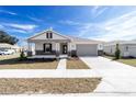 Inviting single-story home with a covered porch, manicured lawn, and a two-car garage at 5589 Sw 78Th Ave Rd, Ocala, FL 34474