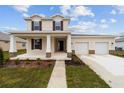 Charming two-story home with a welcoming front porch, a two-car garage, and landscaped front yard at 7821 Sw 55Th Ln, Ocala, FL 34474