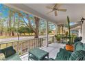 Relaxing front porch with green wicker furniture, plants, and ceiling fan overlooking scenic neighborhood at 8891 Sw 96Th Ln # E, Ocala, FL 34481