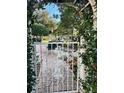 Charming garden gate entrance with lush greenery and a brick path leading to the backyard at 9133 Sw 91St Cir, Ocala, FL 34481