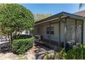 Enclosed patio with brick flooring featuring a black grill and trimmed bushes at 9133 Sw 91St Cir, Ocala, FL 34481