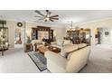 Comfortable living room featuring plush sofas, a ceiling fan, and views into the dining area at 9483 Sw 90Th St, Ocala, FL 34481