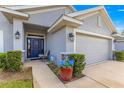 Close up of front entrance with blue potted flowers, stone accents, and a gray stucco facade at 1 Diamond Cove Pl, Ocala, FL 34472