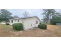 Rear exterior of this one-story home, with mature landscaping and traditional shutters at 10060 Sw 93Rd Ave, Ocala, FL 34481