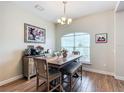 Bright dining room featuring wood floors, decorative chandelier, and a large window at 1083 Se 65Th Cir, Ocala, FL 34472