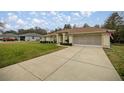 A well-maintained home featuring a spacious driveway, a two-car garage, and manicured landscaping at 10884 Sw 53Rd Cir, Ocala, FL 34476