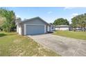 A well-maintained home with an attached garage, long driveway, and tidy lawn space at 11862 Se 72Nd Terrace Rd, Belleview, FL 34420