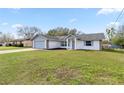 Inviting single-story home with a spacious lawn, attached garage, and attractive exterior design at 11862 Se 72Nd Terrace Rd, Belleview, FL 34420