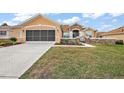 Attractive home featuring stone accents, manicured lawn, and a spacious driveway leading to a two-car garage at 13096 Se 93Rd Terrace Road, Summerfield, FL 34491