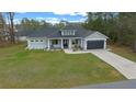 A beautiful home with a well-kept front lawn, gray garage door, and excellent curb appeal from an aerial perspective at 13105 Sw 73Rd Avenue Rd, Ocala, FL 34473