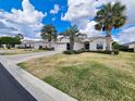 Inviting home featuring mature palm trees, a paver driveway, and a well-maintained lawn and landscaping at 15857 Sw 11Th Terrace Rd, Ocala, FL 34473