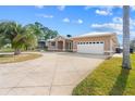 Beautiful single-story home with a large driveway, well-maintained lawn, and neutral tan paint at 1621 Yellow Brick Rd, Astor, FL 32102