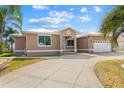 Charming single story home showcasing stucco and white trim, plus a large, patterned concrete driveway at 1621 Yellow Brick Rd, Astor, FL 32102