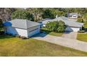 Exterior shot of the home with its long driveway and detached garage on a well-manicured lawn at 1712 Ne 40Th Ave, Ocala, FL 34470
