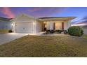 Charming single-story home with a well-manicured lawn and a two-car garage at dusk at 5094 Se 89Th St, Ocala, FL 34480