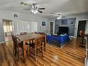 Spacious living room with wood floors, ceiling fans, a dining table, and access to the adjacent areas at 5155 Sw 39Th St, Ocala, FL 34474