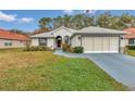 Inviting home with a manicured lawn, a driveway, and a convenient two-car garage enhancing its curb appeal at 6793 Sw 111Th Loop, Ocala, FL 34476