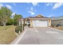 Inviting single-story home featuring a two-car garage, landscaped front yard, and walkway to front door at 9285 Sw 90Th St, Ocala, FL 34481