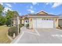 Desirable home featuring two-car garage, decorative shrubbery, walkway to front door, and appealing architecture at 9285 Sw 90Th St, Ocala, FL 34481