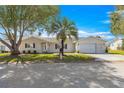 Charming single-story home with lush landscaping, palm tree and an attached two-car garage at 9884 Se 175Th Pl, Summerfield, FL 34491