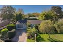 An eye-level aerial view of the home with a landscaped yard, mature trees, and an inviting driveway at 10958 Sw 86Th Ct, Ocala, FL 34481