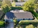 A high-angle aerial view of the home with a dark roof, mature trees, and manicured landscaping at 10958 Sw 86Th Ct, Ocala, FL 34481